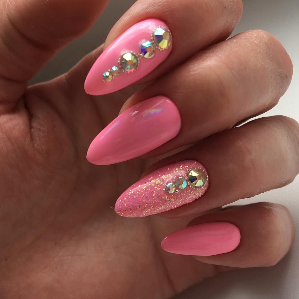 Рожевий колір на нарощених нігтях із крупними камінцями та глітером