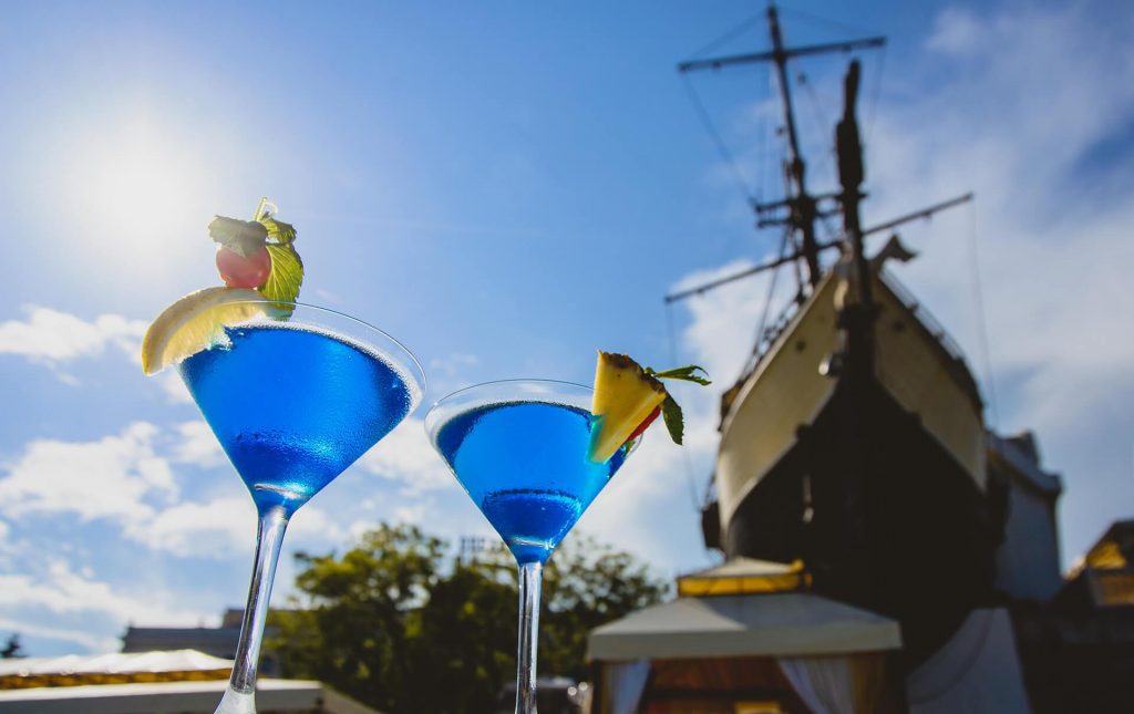 Два коктейля синего цвета на фоне корабля и неба