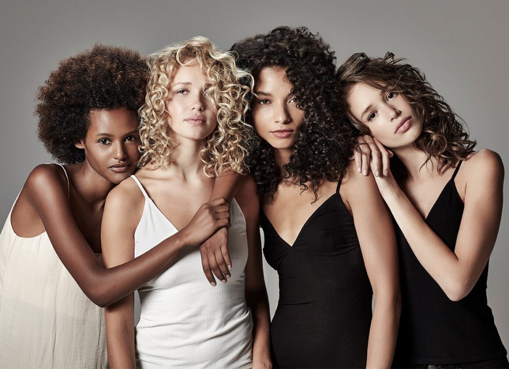 Четыре девушки разного цветотипа с кудрявыми волосами