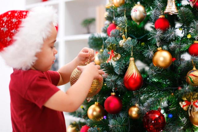 Ребенок украшает елку на новый год