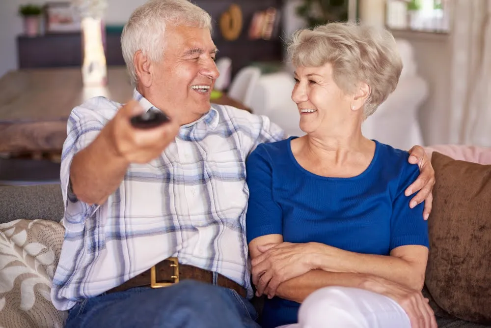 Пожилые мужчина и женщина смотрят телевизор